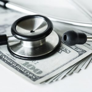 Closeup of cash and a stethoscope healthcare and expenses concept